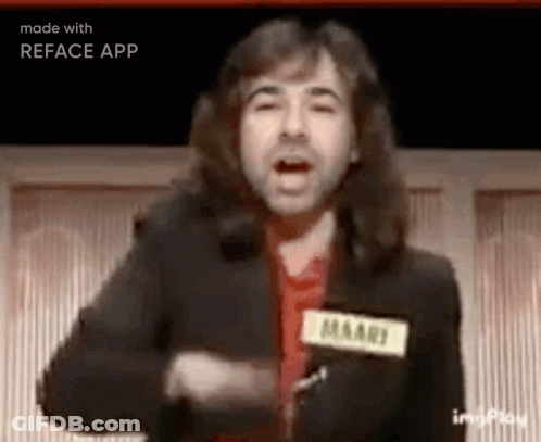 A Man With Long Hair Is Standing In Front Of A Microphone And Talking . GIF