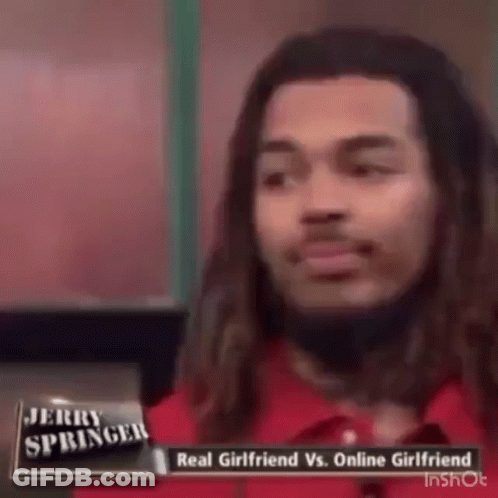 A Man With Long Hair Is Talking On Jerry Springer 'S Show About A Real Girlfriend Vs. Online Girlfriend . GIF