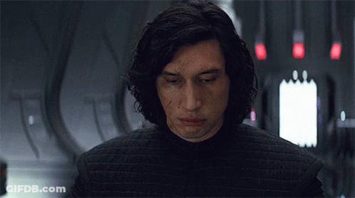 A Man With Long Hair Is Wearing A Black Jacket And Looking At The Camera . GIF
