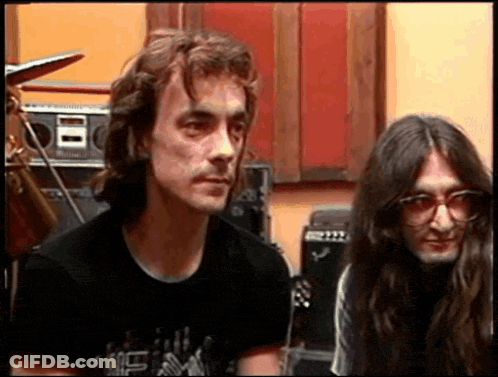 A Man With Long Hair Is Wearing A Black Shirt That Says ' I Love You ' On The Front GIF