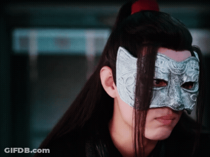 A Man With Long Hair Is Wearing A Mask On His Face . GIF