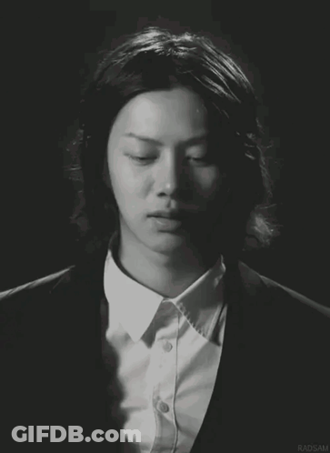A Man With Long Hair Is Wearing A Suit And A White Shirt With Radsam Written On The Bottom GIF