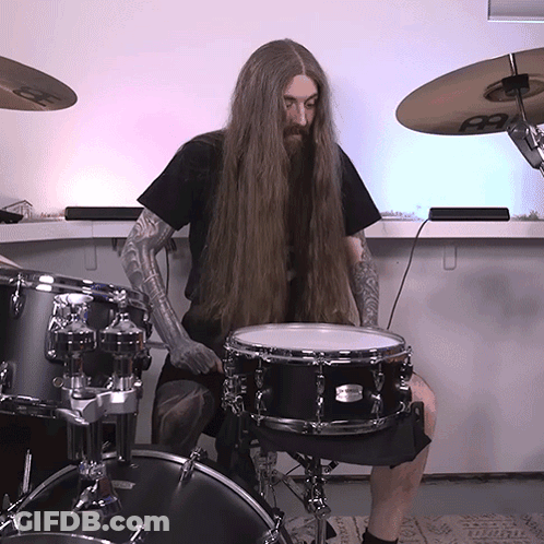 A Man With Long Hair Playing A Drum Set GIF