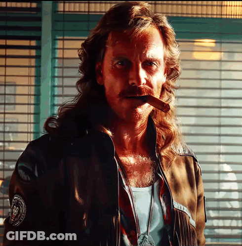 A Man With Long Hair Smoking A Cigar With A Patch On His Jacket That Says ' N.p.d. ' GIF