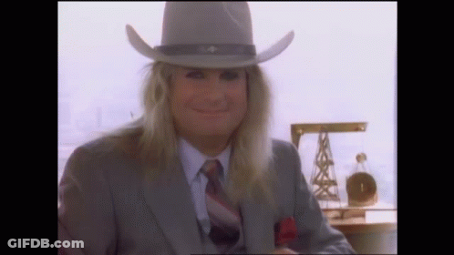 A Man With Long Hair Wearing A Cowboy Hat And Suit GIF