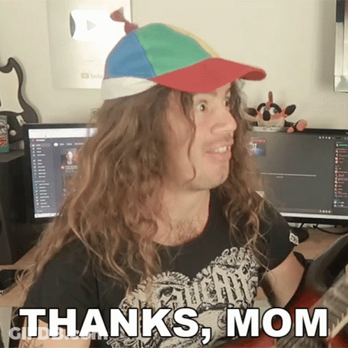 A Man With Long Hair Wearing A Hat And A Shirt That Says " Thanks Mom " GIF