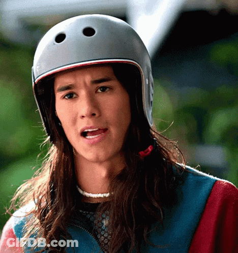 A Man With Long Hair Wearing A Helmet Making A Funny Face GIF