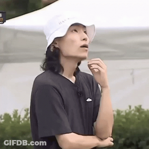 A Man With Long Hair Wearing A White Hat And A Black T-Shirt . GIF