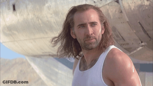 A Man With Long Hair Wearing A White Tank Top GIF