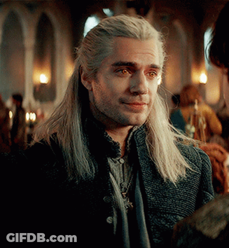 A Man With Long White Hair And A Beard Is Wearing A Black Jacket And Scarf . GIF