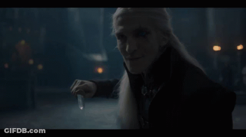 A Man With Long White Hair Is Holding A Candle In His Hand GIF