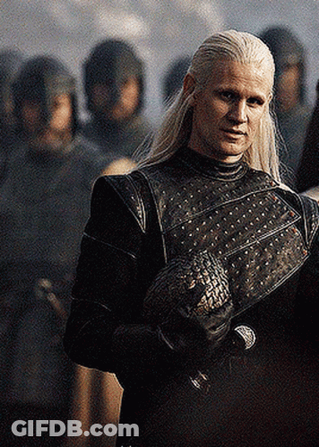 A Man With Long White Hair Is Standing In Front Of A Group Of Soldiers Holding A Dragon . GIF