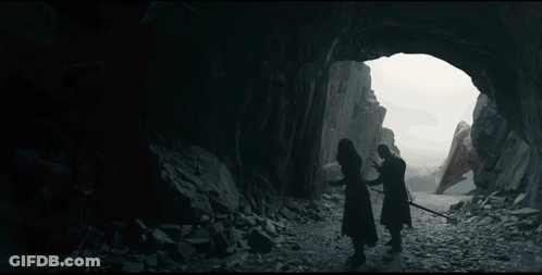A Man With Long White Hair Is Standing In Front Of A Rock Wall And Looking At The Camera . GIF