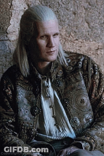 A Man With Long White Hair Is Wearing A Jacket With Buttons GIF