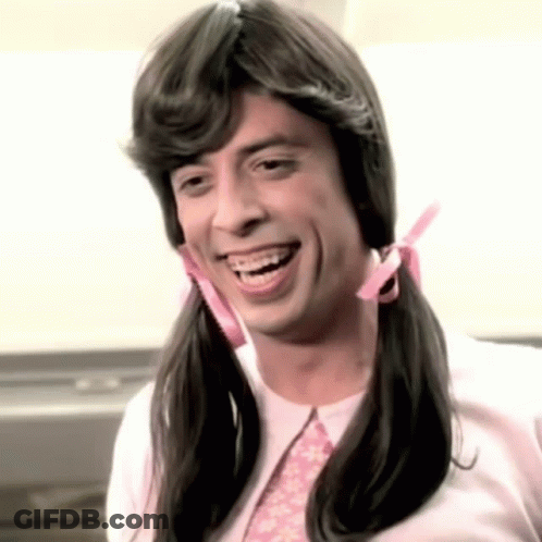 A Man With Pigtails And Braces Smiles For The Camera GIF