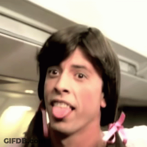A Man With Pigtails Is Sticking His Tongue Out . GIF