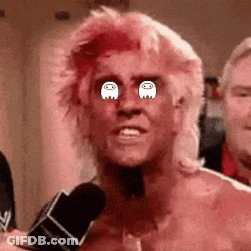 A Man With Pink Hair Is Talking Into A Microphone And Has Ghosts In His Eyes . GIF