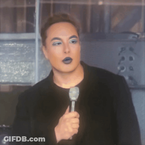 A Man With Purple Eyebrows Is Holding A Microphone In His Hand GIF