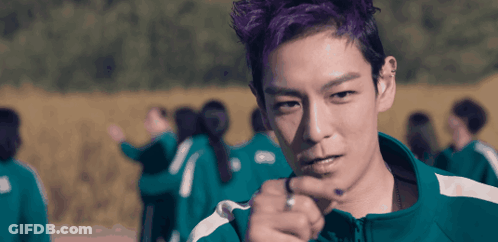 A Man With Purple Hair Is Pointing At Something GIF