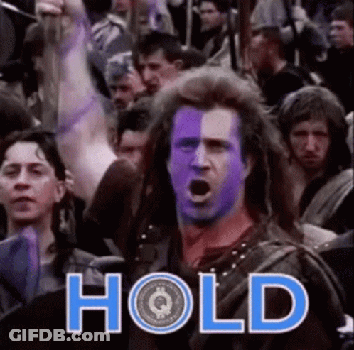 A Man With Purple Paint On His Face Is Standing In Front Of A Crowd With The Word Hold Written On It GIF