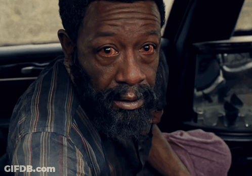 A Man With Red Eyes And A Beard Looks At The Camera GIF