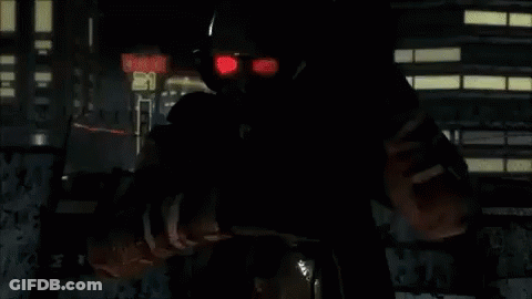 A Man With Red Eyes Is Standing In Front Of A Sign That Says ' Exit ' On It GIF