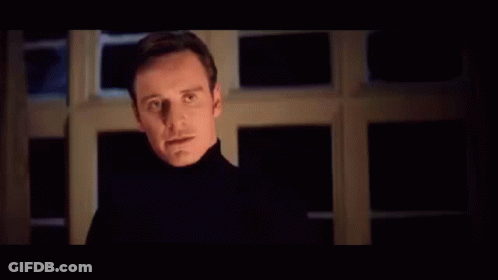 A Man With Red Eyes Is Standing In Front Of A Sign That Says Perfection In Blue Letters . GIF