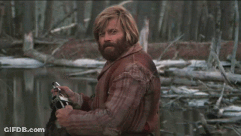 A Man With Red Hair And A Beard Is Holding A Camera In His Hand GIF