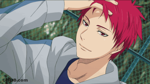 A Man With Red Hair And A Blue Shirt Is Standing In Front Of A Fence GIF