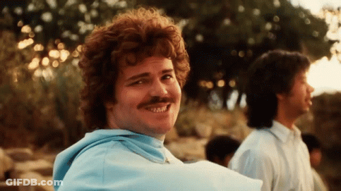 A Man With Red Hair And A Mustache Smiles For The Camera GIF