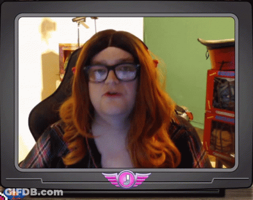 A Man With Red Hair And Glasses Is On A Tv Screen With A Pink Emblem With An Exclamation Point GIF