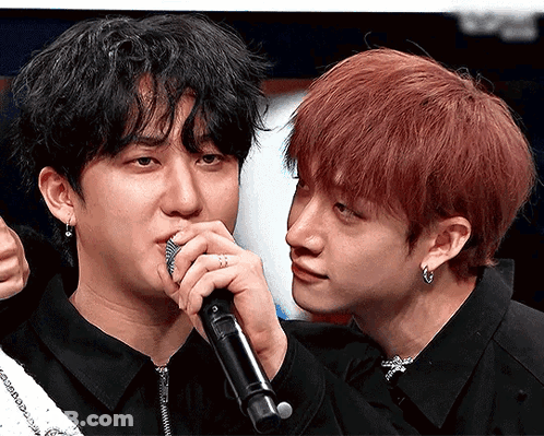 A Man With Red Hair Is Holding A Microphone Next To Another Man GIF