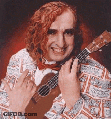 A Man With Red Hair Is Holding A Ukulele And Giving The Middle Finger . GIF