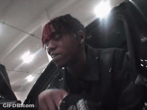 A Man With Red Hair Is Sitting In A Car With A Sticker On His Jacket That Says ' A ' On It GIF