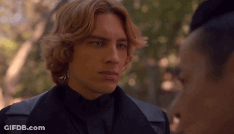 A Man With Red Hair Is Standing Next To A Woman In A Black Jacket . GIF