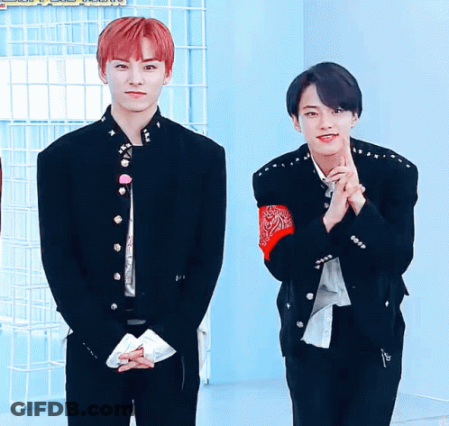 A Man With Red Hair Is Standing Next To Another Man GIF
