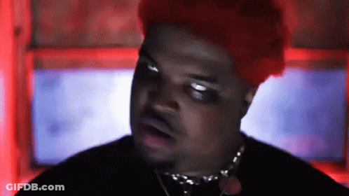 A Man With Red Hair Is Wearing A Black Shirt And Necklace . GIF