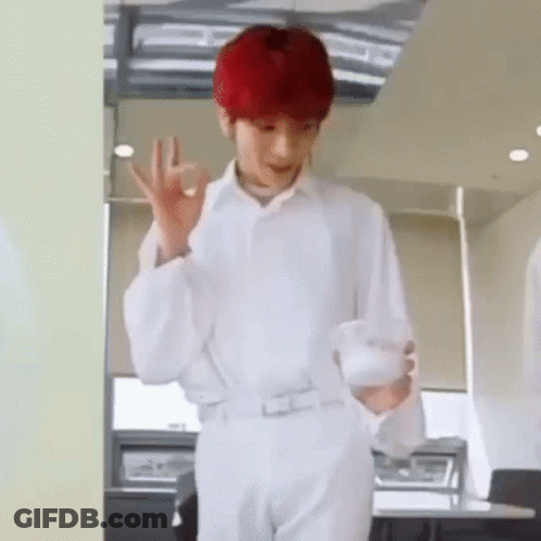 A Man With Red Hair Is Wearing A White Shirt And White Pants And Is Holding A Cup Of Coffee . GIF