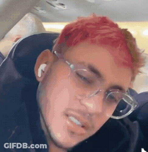 A Man With Red Hair Is Wearing Glasses And Earbuds GIF