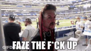 A Man With Red Hair Says Faze The F * Ck Up In Front Of A Football Field . GIF