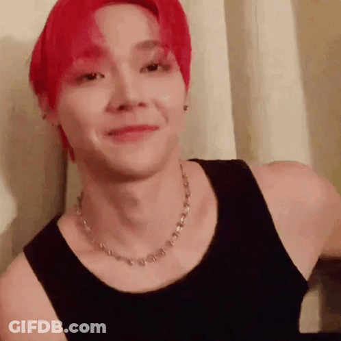 A Man With Red Hair Wearing A Black Tank Top And A Necklace . GIF