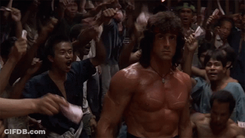 A Man With Red Paint On His Body Is Standing In Front Of A Crowd GIF