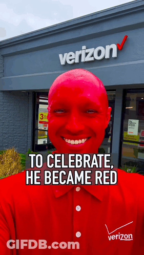 A Man With Red Paint On His Face Is Smiling In Front Of A Verizon Store GIF