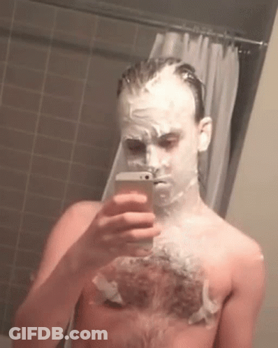 A Man With Shaving Cream On His Face Is Taking A Picture Of Himself GIF