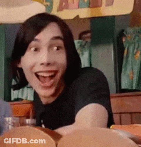 A Man With Short Hair Is Smiling With His Mouth Open GIF
