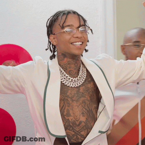 A Man With Tattoos On His Chest Is Wearing Glasses GIF