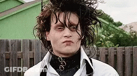 A Man With Wet Hair Is Making A Funny Face In Front Of A Fence . GIF
