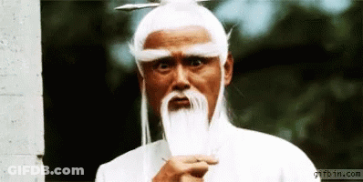 A Man With White Hair And A Beard Is Standing In Front Of A Gifbin.com Sign GIF