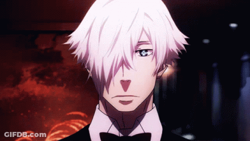 A Man With White Hair And A Bow Tie Looks At The Camera GIF