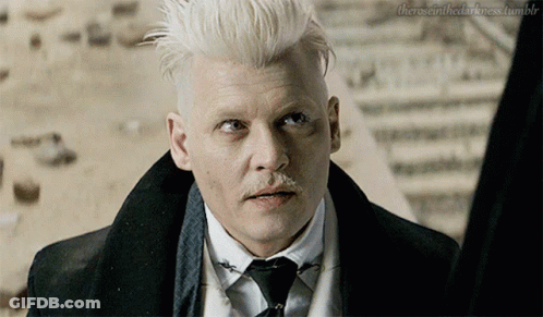 A Man With White Hair And A Mustache Is Looking At Something GIF